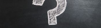 white question mark on a black chalkboard background