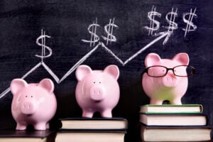 three piggy banks in front of chalk board