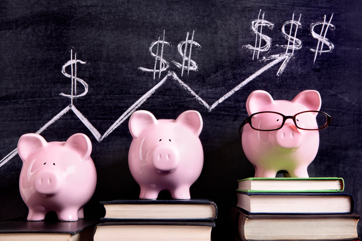 three piggy banks in front of chalk board
