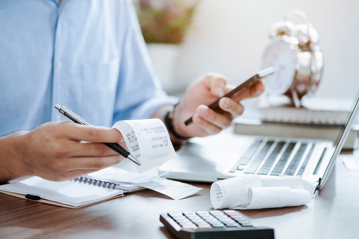 Man struggling with paper expense receipts